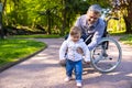 Dad on wheelchair playing with his little son in the park Royalty Free Stock Photo