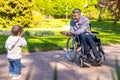 Dad on wheelchair playing with his little son in the park Royalty Free Stock Photo