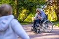 Dad on wheelchair playing with his little son in the park Royalty Free Stock Photo