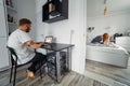 Dad works at laptop, mom and baby on the bed Royalty Free Stock Photo