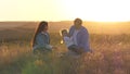 Daddy baby and mom are playing outdoors. Happy family plays with their little daughter in park on grass in rays of Royalty Free Stock Photo