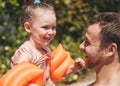 Daddy ca teach you how to swim. an adorable little learning to swim with her father.