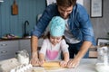 Daddy with daughter baking cake together in home kitchen.