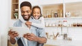 Daddy and daughter having video call on tablet in kitchen Royalty Free Stock Photo