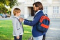 Daddy giving support his son for beggining school. Schoolboy go to first class. Education, elementary school