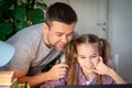 Daddy helps daughter with online lessons on laptop