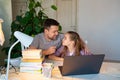 Daddy helps girl with online lessons on laptop