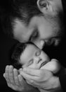 Daddy hugs his newborn baby. Father `s love. Close-up portrait on a black background Royalty Free Stock Photo