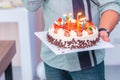 Daddy lighting birthday candles on birthday cake for children