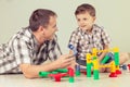 Daddy with little boy playing with toy on the floor at the day