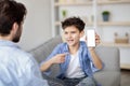 Daddy, look. Happy boy showing cellphone with white blank screen to father and pointing on it, place for mockup Royalty Free Stock Photo
