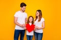 Daddy mommy and little foxy lady posing for family portrait with big paper heart wear casual clothes isolated yellow Royalty Free Stock Photo