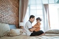 Daddy plays with his little daughter while sitting on the bed Royalty Free Stock Photo