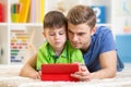 Daddy and son websurfing on digital tablet at home Royalty Free Stock Photo