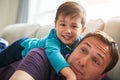 Daddy time is happy time. an adorable little boy and his father playing together on the sofa at home. Royalty Free Stock Photo