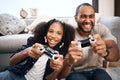 Daddys raising a real winner. a young girl playing video games with her father at home. Royalty Free Stock Photo