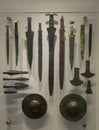 Daggers and swords, one with gilded nails and other with bone handles, spears, axe- shaped tools and two small bassed shields.