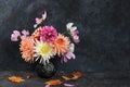 Dahlias and daisies in a vase on a dark old grunge background.Autumn abstract composition, Thanksgiving day concept, seasonal Royalty Free Stock Photo