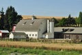 White Barn with Wheels as Fence Royalty Free Stock Photo