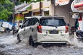 a Daihatsu Sigra car that hit a flood during heavy rain on a residential road