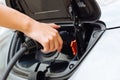 Dainty female hands charging an electric car