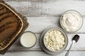 Dairy farm food: curd cheese and cream in bowls, milk and fresh bread in basket on rustic background, top view with copy space Royalty Free Stock Photo