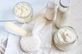 Dairy products. Milk in glass bottle, yogurt, sour milk cheese, sour cream in glass jar, camembert, brie on light wooden table