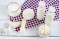 Dairy products. Milk in glass bottle, yogurt, sour milk cheese, sour cream in glass jar, camembert, brie on light wooden table Royalty Free Stock Photo