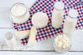 Dairy products. Milk in glass bottle, yogurt, sour milk cheese, sour cream in glass jar, camembert, brie on light wooden table