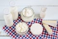 Dairy products. Milk in glass bottle, yogurt, sour milk cheese, sour cream in glass jar, camembert, brie on light wooden table