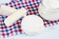 Dairy products. Sour milk cheese, sour cream, camembert and brie with checkered napkin on light blue wooden table Royalty Free Stock Photo