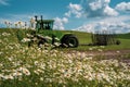 Daisies in bloom with a tractor intentionally blurred in background, with fields of rolling grass hills in The Palouse of Royalty Free Stock Photo