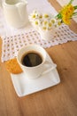 Daisies and dandelions, a cup of coffee and a cookie on a wooden table Royalty Free Stock Photo