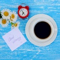 Daisy flowers, alarm clock and cup of coffee Royalty Free Stock Photo