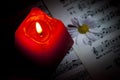 Daisy and Red Candle on Music Notes Sheet Royalty Free Stock Photo