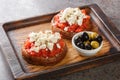 Dakos consists of a slice of cracked barley bread and garnished with crushed or grated ripe tomato and crumbled feta with oregano