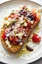 Dakos salad traditional Greek salad with soaked and crunchy barley rusks or bread, topped with juicy tomatoes, feta