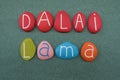 Dalai Lama, spiritual leader given by Tibetan people, creative composition with handmade colored stone letters over green sand