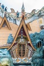 DALAT, VIETNAM - APRIL 15, 2019: Tourists stand on the roof of a wooden house with a window