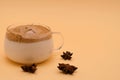 Dalgon coffee in a glass small cup on a beige background. Nearby are anise flowers. Copy space, horizontal background