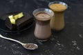 Dalgona coffee and cocoa in glass transparent glasses. Nearby lies a metal spoon with instant coffee, and a chocolate