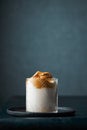 Dalgona coffee in a modern glass on a dark background with lots of space for copy Royalty Free Stock Photo