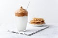 Homemade Dalgona coffee with waffles on light concrete background. Trendy Korean coffee cold drink