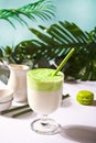 Dalgona Matcha Latte,creamy whipped matcha green tea with plant on the background