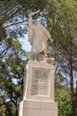 Large stone statue of Elijah - the Prophet stands on a stone pedestal in the garden of the Deir Al-Mukhraqa Carmelite Monastery in