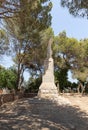 Large stone statue of Elijah - the Prophet stands on a stone pedestal in the garden of the Deir Al-Mukhraqa Carmelite Monastery in