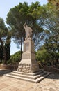 Large stone statue of Elijah - the Prophet stands on a stone pedestal in the garden of the Deir Al-Mukhraqa Carmelite Monastery in