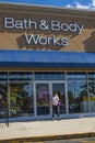 Senior wearing face mask Bath and Body works retail store in a strip mall