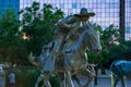 Dallas, Texas - May 7, 2018: Cowboy and longhorn cows with cattle in the background, as part of a landmark bronze cattle