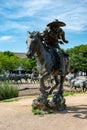 Dallas, Texas - May 7, 2018: Cowboy and longhorn cows with cattle in the background, as part of a landmark bronze cattle